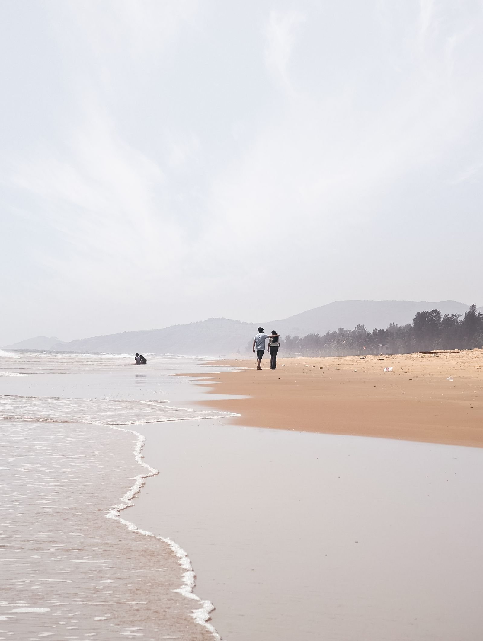 Couple walking the quiet shore at Gokarna