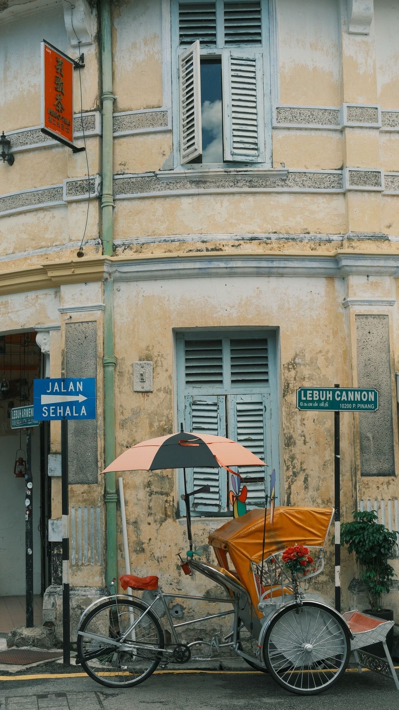 A trishaw by a heritage building in George Town, Penang